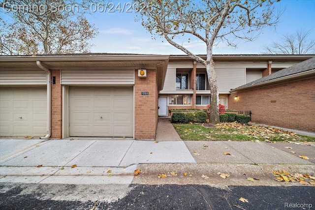 1008 Trevor Pl, Detroit, MI 48207 - multi unit property featuring concrete driveway, brick siding, and a garage
