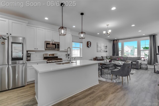 137 Monument Ln, Wixom, MI 48393 - kitchen with appliances with stainless steel finishes, light wood-style floors, a sink, open floor plan, and recessed lighting