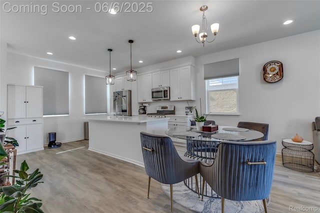 137 Monument Ln, Wixom, MI 48393 - dining area featuring light wood finished floors, a chandelier, recessed lighting, and baseboards
