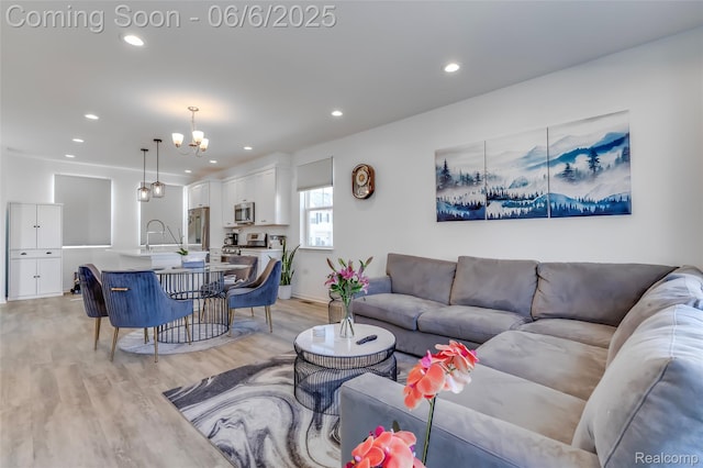 137 Monument Ln, Wixom, MI 48393 - living room featuring light wood finished floors, a chandelier, recessed lighting, and baseboards