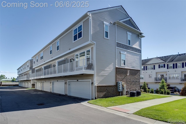 137 Monument Ln, Wixom, MI 48393 - rear view of house with brick siding, central air condition unit, and a lawn