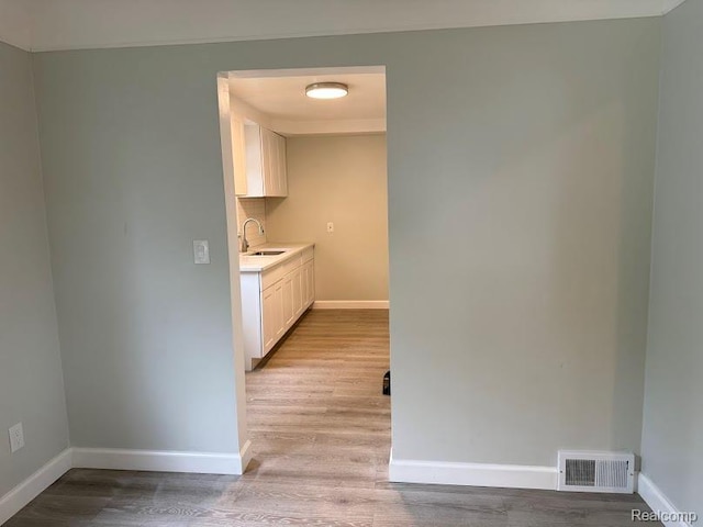 20760 Ridgedale St, Oak Park, MI 48237 - kitchen featuring light wood finished floors, a sink, baseboards, and light countertops