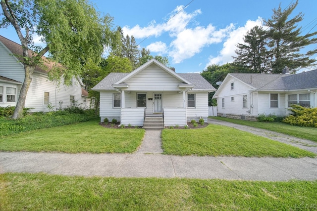 174 W Mansion St, Jackson, MI 49203 - bungalow-style house with covered porch, a front lawn, and a shingled roof