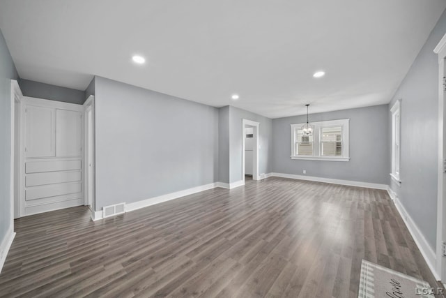 174 W Mansion St, Jackson, MI 49203 - unfurnished living room with dark wood-type flooring, recessed lighting, baseboards, and a chandelier