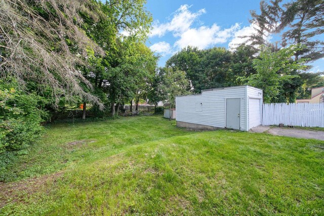 174 W Mansion St, Jackson, MI 49203 - view of yard featuring asphalt driveway, an outbuilding, and a detached garage