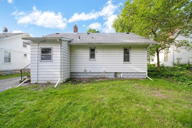 174 W Mansion St, Jackson, MI 49203 - back of house featuring a chimney, a lawn, and roof with shingles