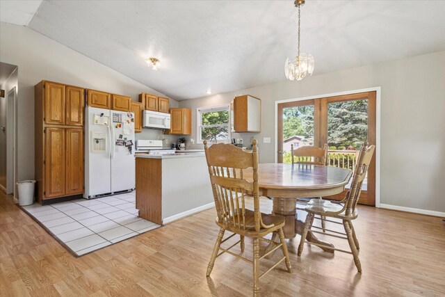 502 Woodland Dr, Buchanan, MI 49107 - dining space featuring lofted ceiling, light wood-style flooring, a chandelier, and baseboards