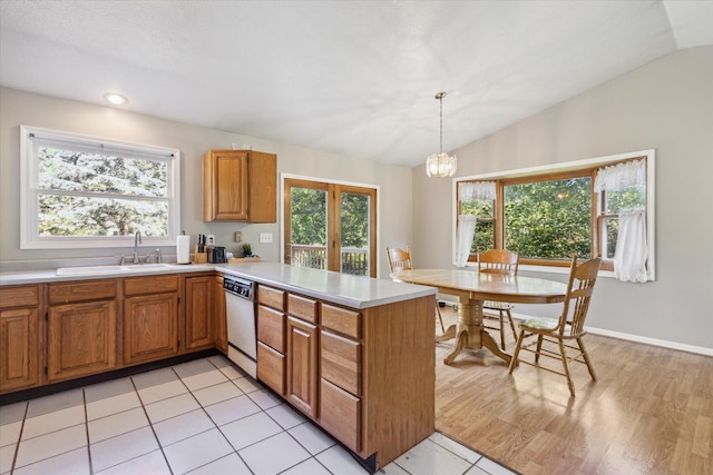502 Woodland Dr, Buchanan, MI 49107 - kitchen with vaulted ceiling, a sink, white dishwasher, light countertops, and a chandelier