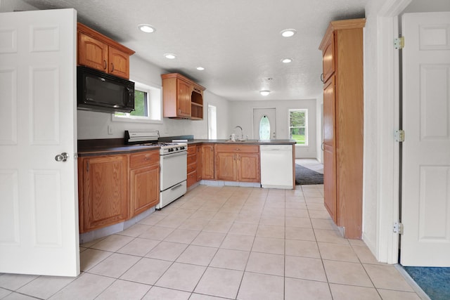 238 Long Ave, Michigan Center, MI 49254 - kitchen featuring white appliances, a peninsula, recessed lighting, healthy amount of natural light, and dark countertops