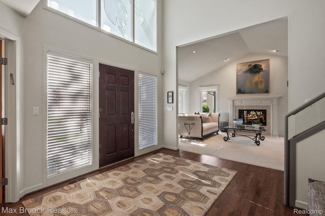 6566 Bristol Dr, West Bloomfield, MI 48322 - entrance foyer featuring a fireplace, wood finished floors, and high vaulted ceiling
