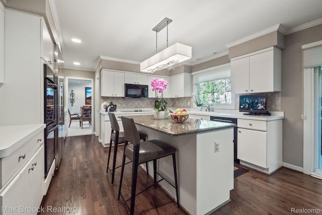 6566 Bristol Dr, West Bloomfield, MI 48322 - kitchen featuring dark wood-style flooring, ornamental molding, white cabinets, a breakfast bar area, and backsplash