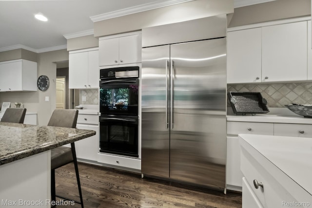 6566 Bristol Dr, West Bloomfield, MI 48322 - kitchen with stainless steel built in refrigerator, crown molding, tasteful backsplash, white cabinetry, and dark wood finished floors