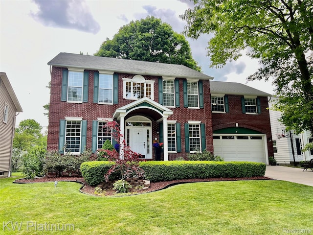 3105 E Woodland Dr, Port Huron, MI 48060 - colonial-style house featuring a garage, driveway, brick siding, and a front lawn