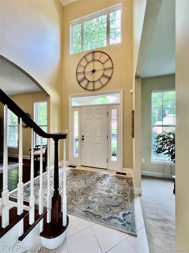 3105 E Woodland Dr, Port Huron, MI 48060 - carpeted entryway with a high ceiling, arched walkways, tile patterned floors, and stairway