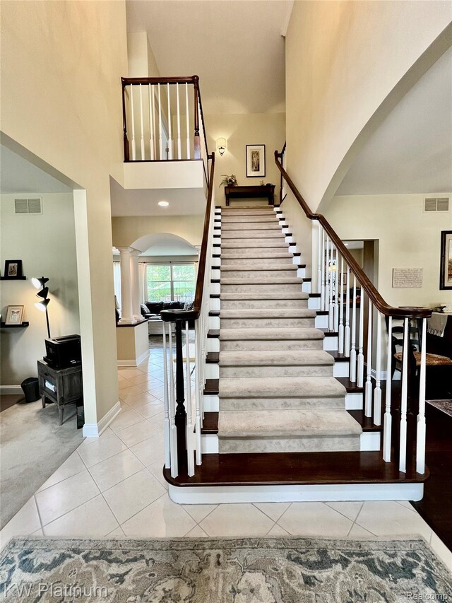 3105 E Woodland Dr, Port Huron, MI 48060 - stairway with arched walkways, decorative columns, tile patterned floors, and a towering ceiling