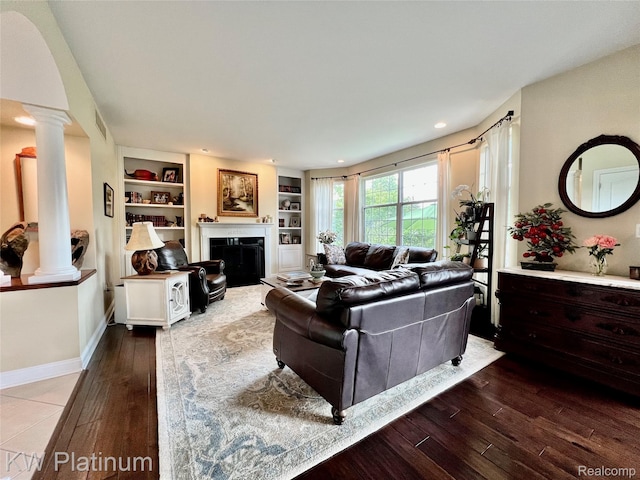 3105 E Woodland Dr, Port Huron, MI 48060 - living room with ornate columns, dark wood-type flooring, built in shelves, a fireplace, and recessed lighting