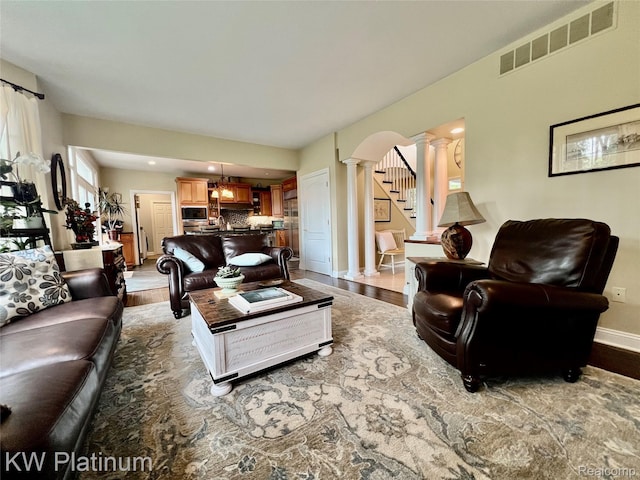 3105 E Woodland Dr, Port Huron, MI 48060 - living area with decorative columns, wood finished floors, and stairway
