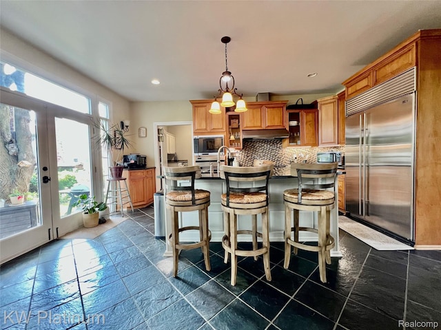 3105 E Woodland Dr, Port Huron, MI 48060 - kitchen with built in appliances, dark countertops, decorative backsplash, open shelves, and under cabinet range hood