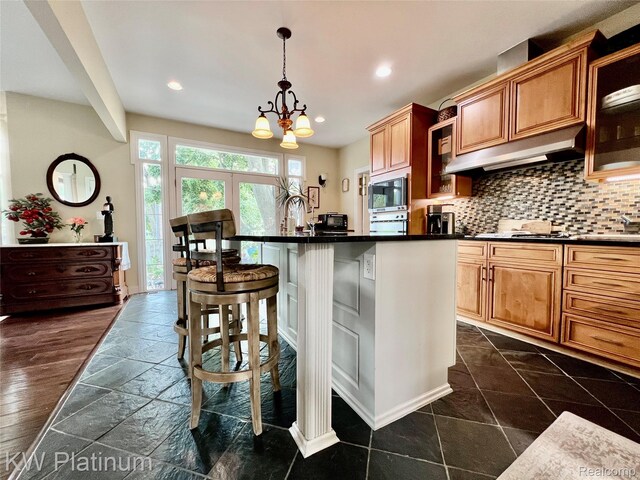 3105 E Woodland Dr, Port Huron, MI 48060 - kitchen featuring dark countertops, under cabinet range hood, built in microwave, a chandelier, and recessed lighting