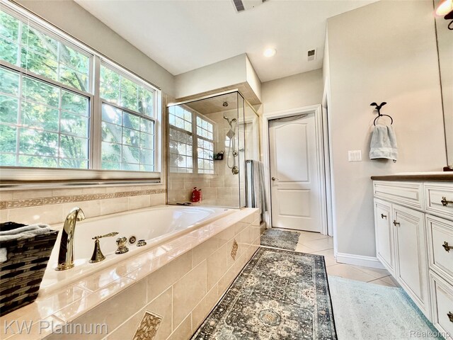 3105 E Woodland Dr, Port Huron, MI 48060 - bathroom featuring a garden tub, a shower stall, tile patterned flooring, and vanity