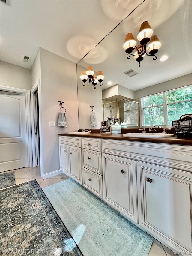 3105 E Woodland Dr, Port Huron, MI 48060 - bathroom featuring a chandelier, double vanity, tile patterned flooring, and a shower with door