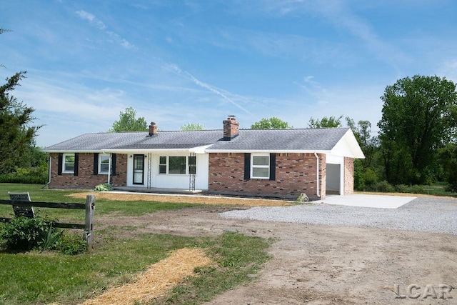 1443 N Posey Lake Rd, Hudson, MI 49247 - ranch-style home with concrete driveway, a chimney, brick siding, and an attached garage