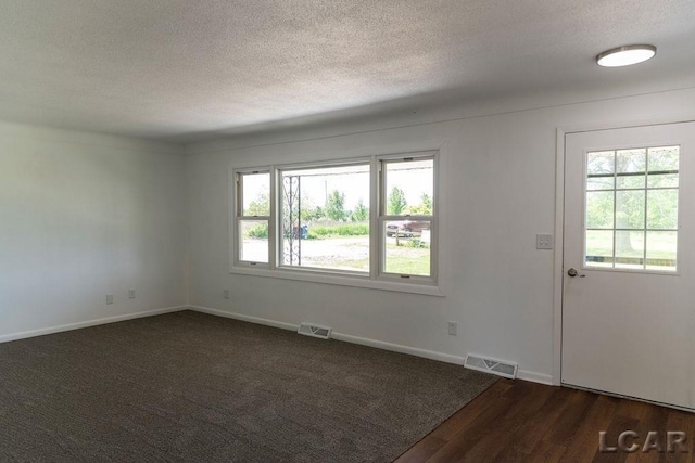 1443 N Posey Lake Rd, Hudson, MI 49247 - spare room with a textured ceiling, baseboards, and dark wood-type flooring