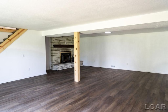 1443 N Posey Lake Rd, Hudson, MI 49247 - unfurnished living room with dark wood-type flooring, a stone fireplace, stairs, and baseboards