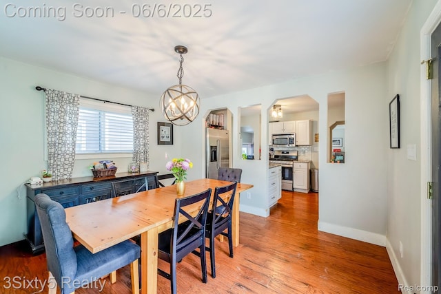 3831 Durham Rd, Royal Oak, MI 48073 - dining space with light wood finished floors, a chandelier, arched walkways, and baseboards
