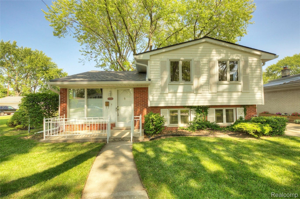 5489 Academy St, Dearborn Heights, MI 48125 - split level home featuring a front yard, brick siding, and covered porch