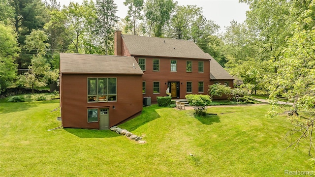 2694 Wayside Dr, Ann Arbor, MI 48103 - rear view of house featuring a chimney, a yard, central air condition unit, and roof with shingles