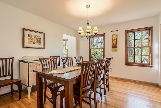 2694 Wayside Dr, Ann Arbor, MI 48103 - dining room featuring healthy amount of natural light, light wood-type flooring, a chandelier, and baseboards