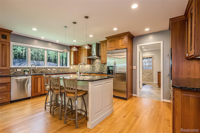 2694 Wayside Dr, Ann Arbor, MI 48103 - kitchen with appliances with stainless steel finishes, wall chimney range hood, dark stone countertops, tasteful backsplash, and recessed lighting