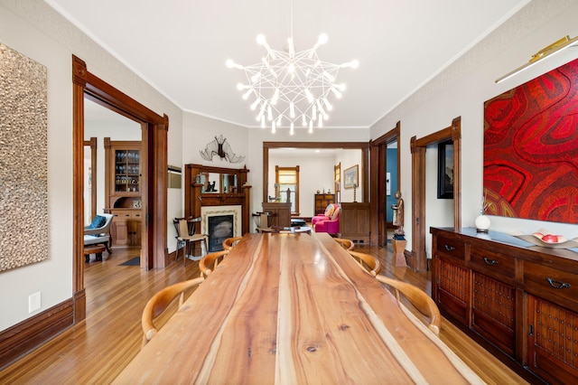 903 Lake Blvd, Saint Joseph, MI 49085 - dining space featuring a chandelier, wood finished floors, ornamental molding, and a fireplace