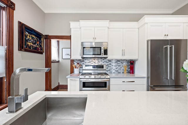 903 Lake Blvd, Saint Joseph, MI 49085 - kitchen featuring stainless steel appliances, a sink, light countertops, tasteful backsplash, and white cabinetry