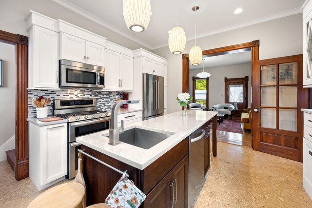 903 Lake Blvd, Saint Joseph, MI 49085 - kitchen featuring appliances with stainless steel finishes, a sink, an island with sink, light countertops, and ornamental molding