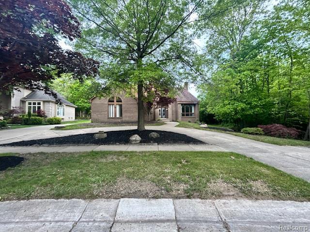 6880 Burtonwood Dr, West Bloomfield, MI 48322 - view of property hidden behind natural elements featuring curved driveway