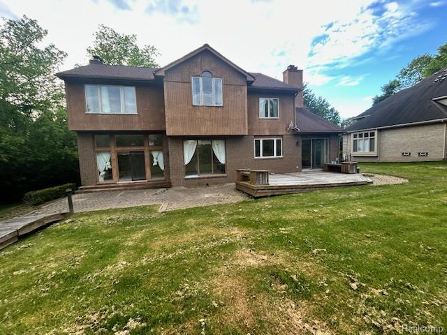 6880 Burtonwood Dr, West Bloomfield, MI 48322 - rear view of property featuring a chimney, a yard, a deck, and central AC unit
