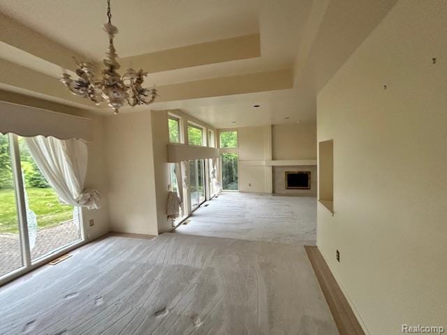 6880 Burtonwood Dr, West Bloomfield, MI 48322 - unfurnished living room with a chandelier, baseboards, a raised ceiling, light wood-style floors, and a fireplace