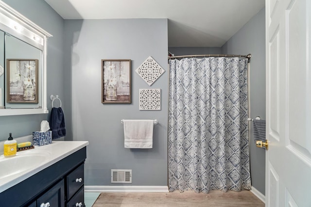 11815 Waldron Rd, Jerome, MI 49249 - bathroom featuring vanity, wood finished floors, baseboards, and curtained shower