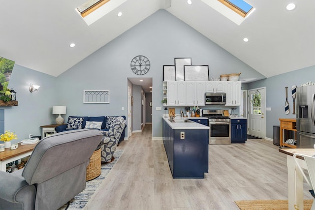 11815 Waldron Rd, Jerome, MI 49249 - kitchen featuring stainless steel appliances, a skylight, high vaulted ceiling, open floor plan, and white cabinets