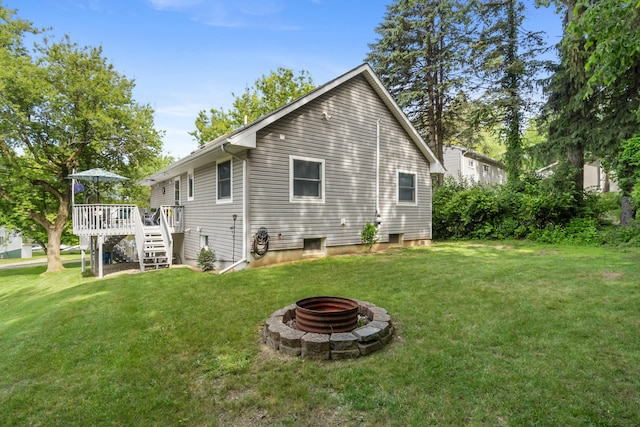 11815 Waldron Rd, Jerome, MI 49249 - back of property with an outdoor fire pit, stairway, a wooden deck, and a lawn
