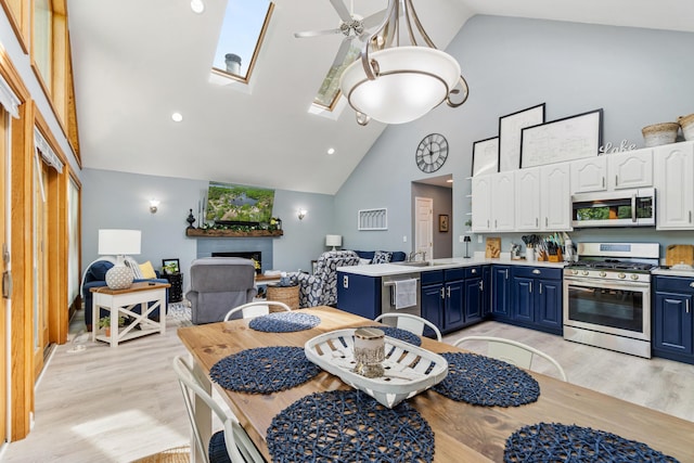 11815 Waldron Rd, Jerome, MI 49249 - kitchen with appliances with stainless steel finishes, blue cabinets, high vaulted ceiling, white cabinets, and a skylight