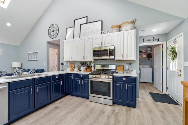 11815 Waldron Rd, Jerome, MI 49249 - kitchen featuring stainless steel appliances, washer / dryer, blue cabinetry, a sink, and light wood-style floors