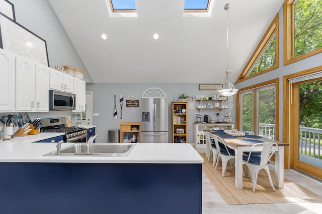 11815 Waldron Rd, Jerome, MI 49249 - kitchen with stainless steel appliances, high vaulted ceiling, a sink, a skylight, and a peninsula
