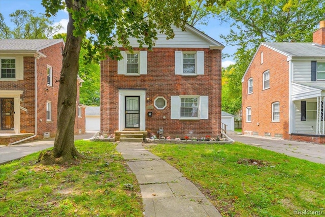14393 Faust Ave, Detroit, MI 48223 - view of front of home with brick siding, an outbuilding, a front lawn, and a detached garage