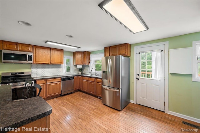 5125 Clarkston Rd, Clarkston, MI 48348 - kitchen with appliances with stainless steel finishes, a sink, brown cabinets, and healthy amount of natural light