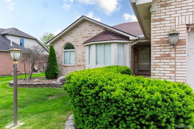 53395 Andrew Cir, New Baltimore, MI 48047 - view of front of home with brick siding, a front yard, and a shingled roof