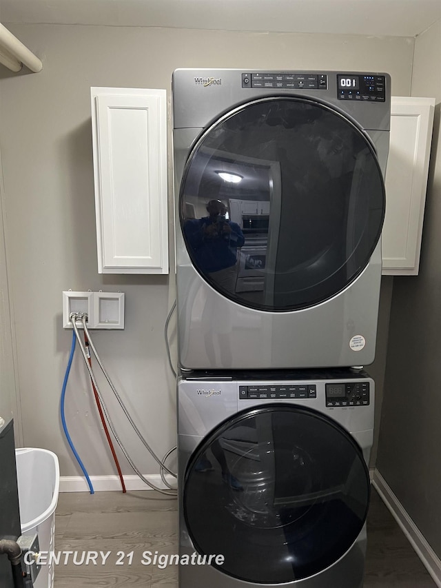 2080 E Schumacher St, Burton, MI 48529 - washroom with stacked washer / drying machine, cabinet space, wood finished floors, and baseboards