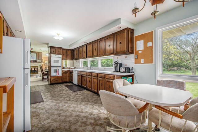 1205 Sassafras Ln, Niles, MI 49120 - kitchen with white appliances, dark carpet, light countertops, tasteful backsplash, and a sink